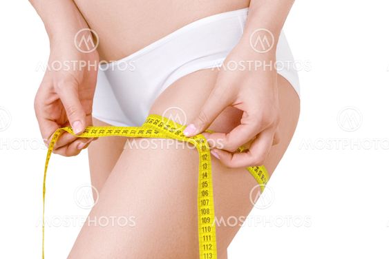 Slim woman in white underwear and measure around her leg on isolated background.