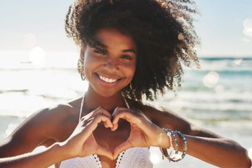 Beach, heart and portrait of woman by ocean for...