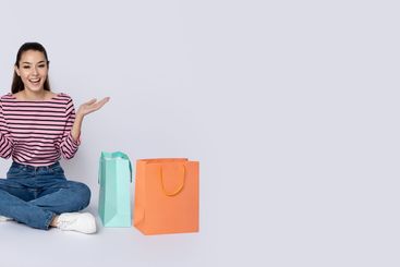 Thrilled happy young brunette woman with shopping bags