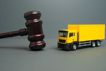 Yellow truck and judge's gavel. Court case. New laws and...
