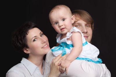 Parents hold their baby studio