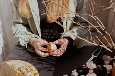 Female hands making egg shell handmade decoration for...