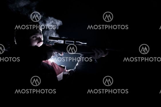 young man shooting with a rifle (color toned image)