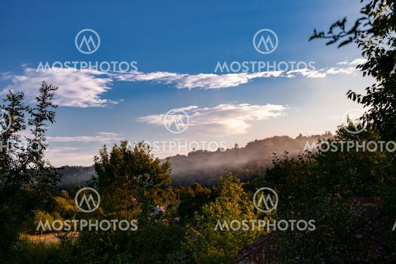 Pastoral Hazy Sunset over Small Village and Valley