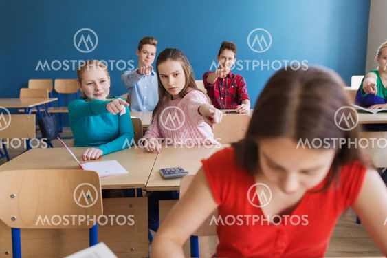 students gossiping behind classmate back at school