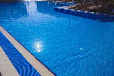 Serene blue swimming pool under sunlight during a clear...