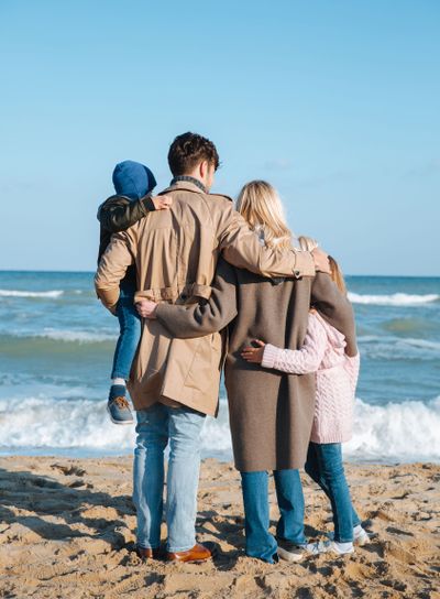 family hugging on seashore