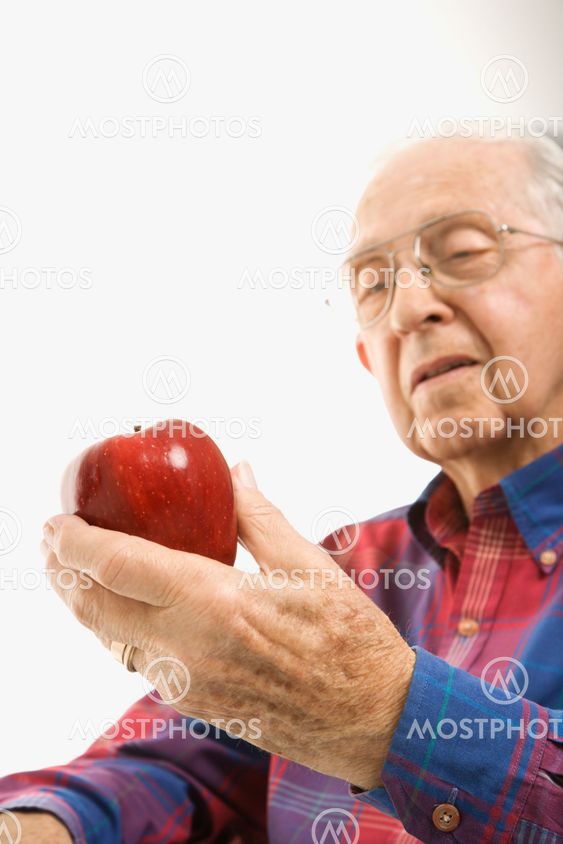 Elderly man holding apple.