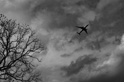 Silhouette commercial airplane on grey sky and clouds...