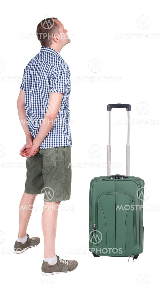 Back view of young man traveling with suitcas.
