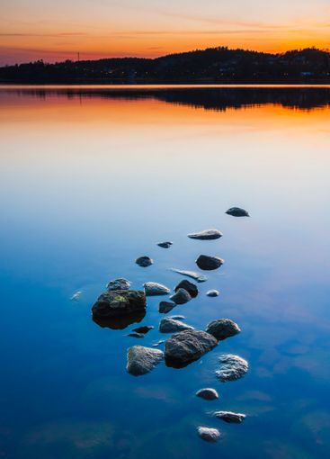 Rocks break the calm surface of Lake Radasjon