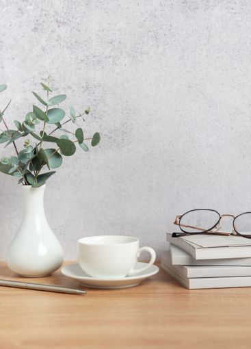 Eucalyptus branches, coffee cup, books and eyeglasses...