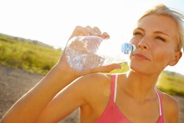 Woman, fitness or drinking water with sunshine in nature...