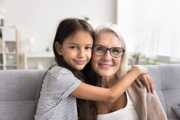 Grateful little granddaughter embrace kind senior...