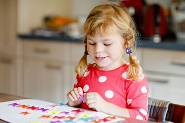 Little toddler girl playing with different colorful...