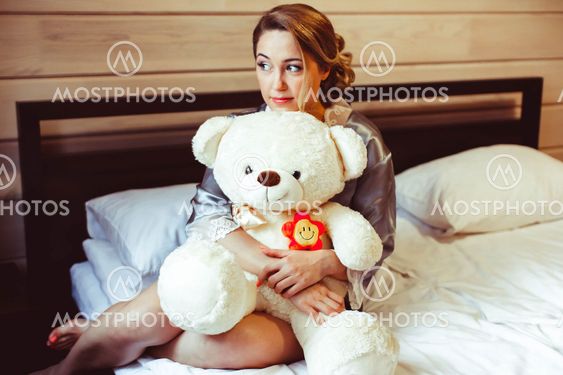 girl sitting on bed with soft toy