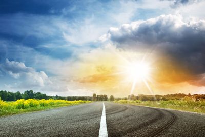 Road view on sunny summer day with dramatic clouds