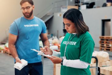 Woman, volunteer and writing on clipboard at warehouse...