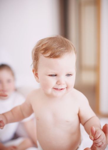 Baby, parent and playing together in home, love and...