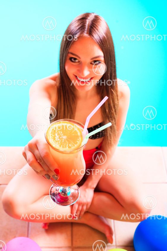 Happy woman with balloons and cocktail at poolside