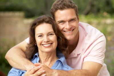 Senior Woman Being Hugged By Adult Son