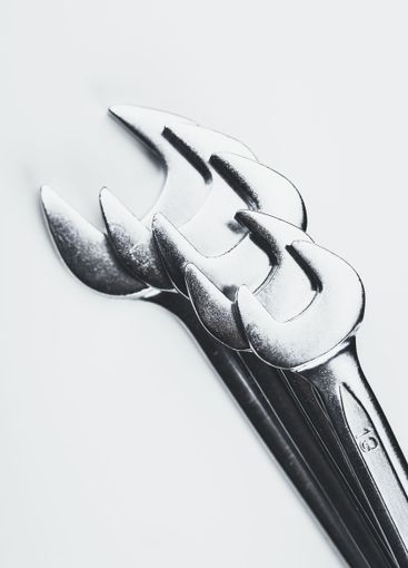 Collection of polished metal tools arranged on a light...