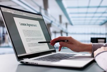 Female businesswoman reviewing leasing contract on laptop