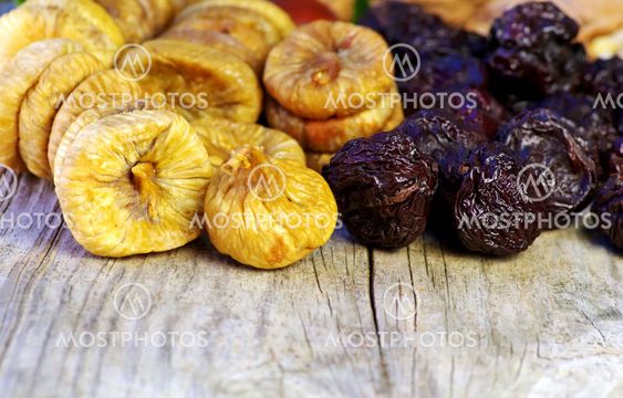 dried plums and figs in wooden table