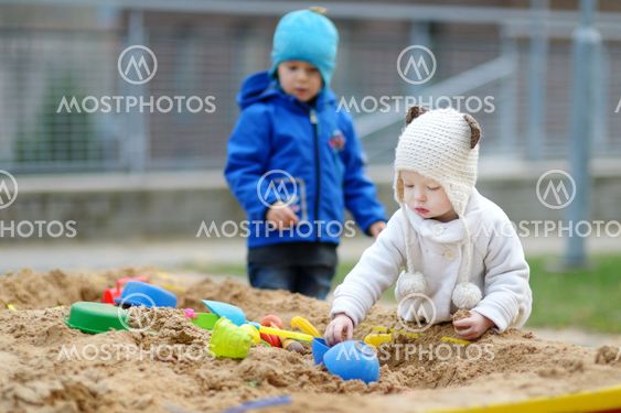 Two kids playing in a sandbox