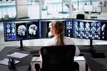Doctors In Clinic Looking At Brain MRI Scan