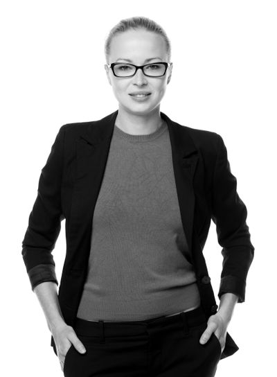 Business woman standing arms in pockets against white...