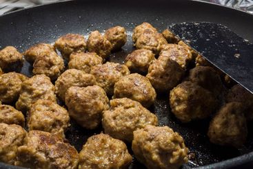Fried meatballs in fry pan close up photo, homemade...