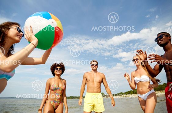 friends playing with beach ball in summer