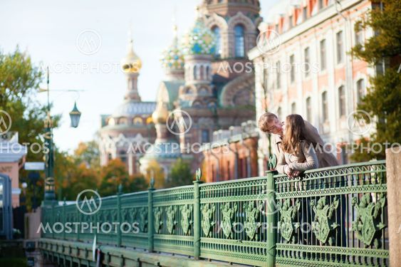 Dating couple on a bridge near the Church of the Savior on Blood in Saint-Petersburg, Russia