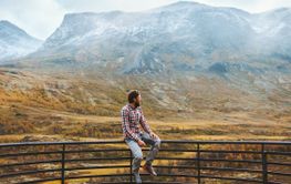 Traveler man in mountains of Norway autumn season travel