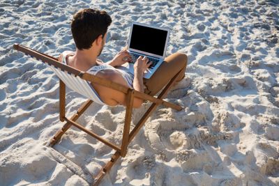 High angle view of man using laptop at beach