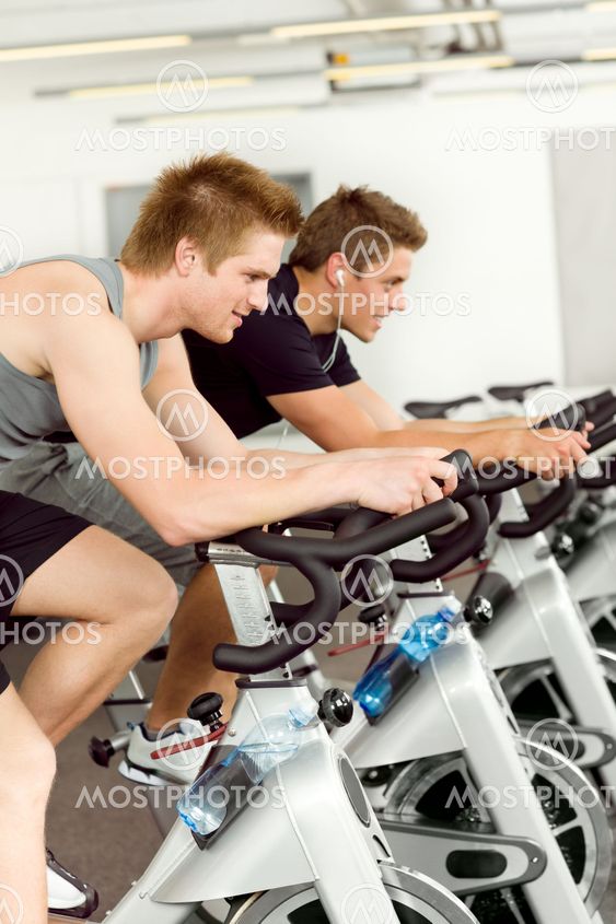 Fitness young man on gym bike spinning