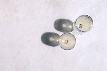 Two elegant long-stemmed glasses with chilled alcoholic...