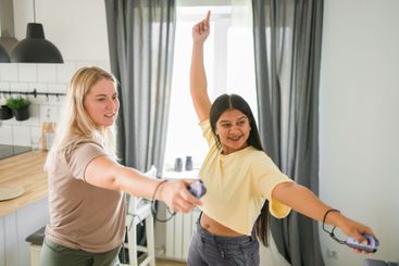 Cheerful group of friends playing video games together...
