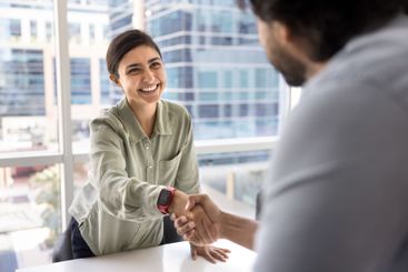 Happy beautiful young Indian businesswoman shaking hands...