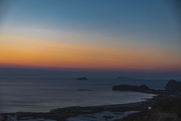 Landscape during evening on calm sea with coast