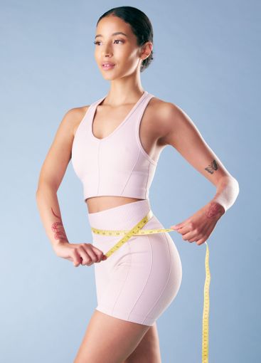 Studio, woman and fitness with tape for measuring,...