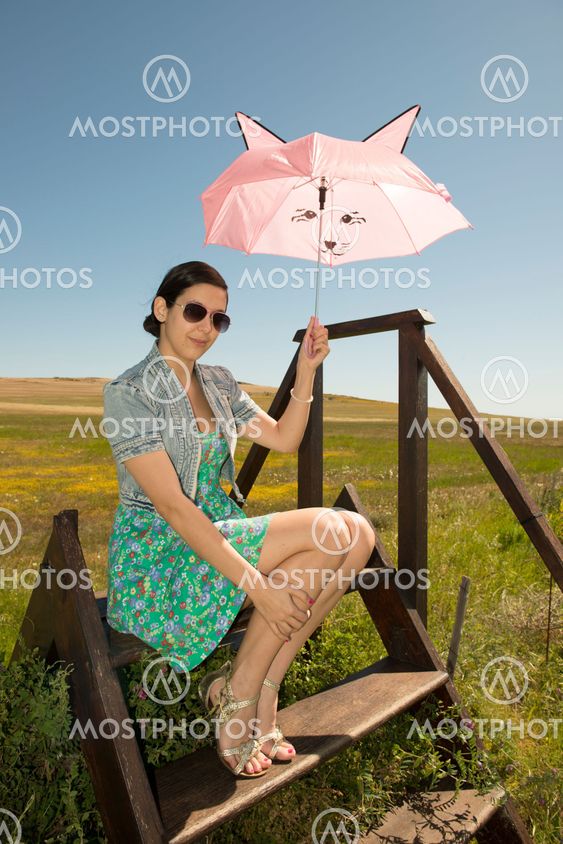 Beautiful adult smelling flowers on sunny field enjoying herself