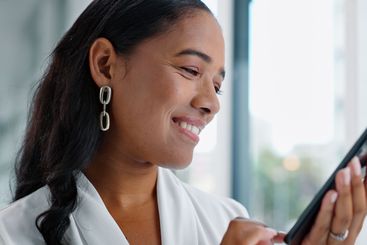 Business woman, tablet and reading in hallway at modern...