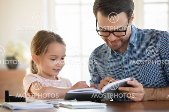 Caring dad teach small preschooler daughter reading
