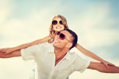 happy father and child in sunglasses over blue sky