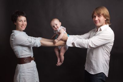 Parents hold their baby studio