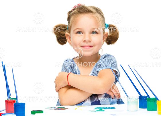 Little girl is painting with gouache