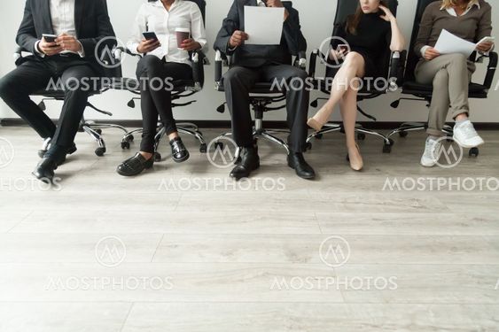 Diverse business people waiting in queue holding smartphones and