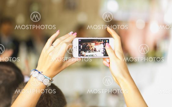 woman making photo on mobile phone at wedding ceremony